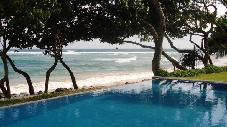 take a dip in the villa's pool while enjoying the sound of the waves and the beautiful sea view